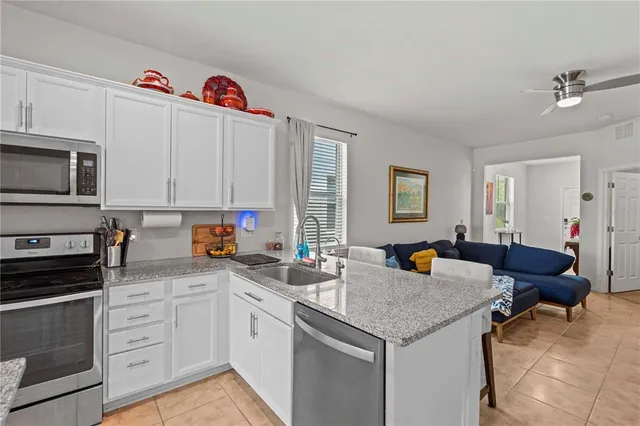 a kitchen with stainless steel appliances granite countertop a sink dishwasher and cabinets with wooden floor