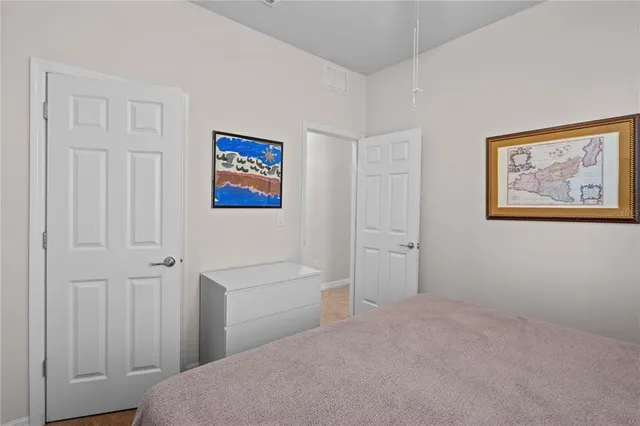 a bedroom with a bed and a painting on the wall