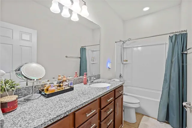 a bathroom with a granite countertop sink mirror vanity and toilet