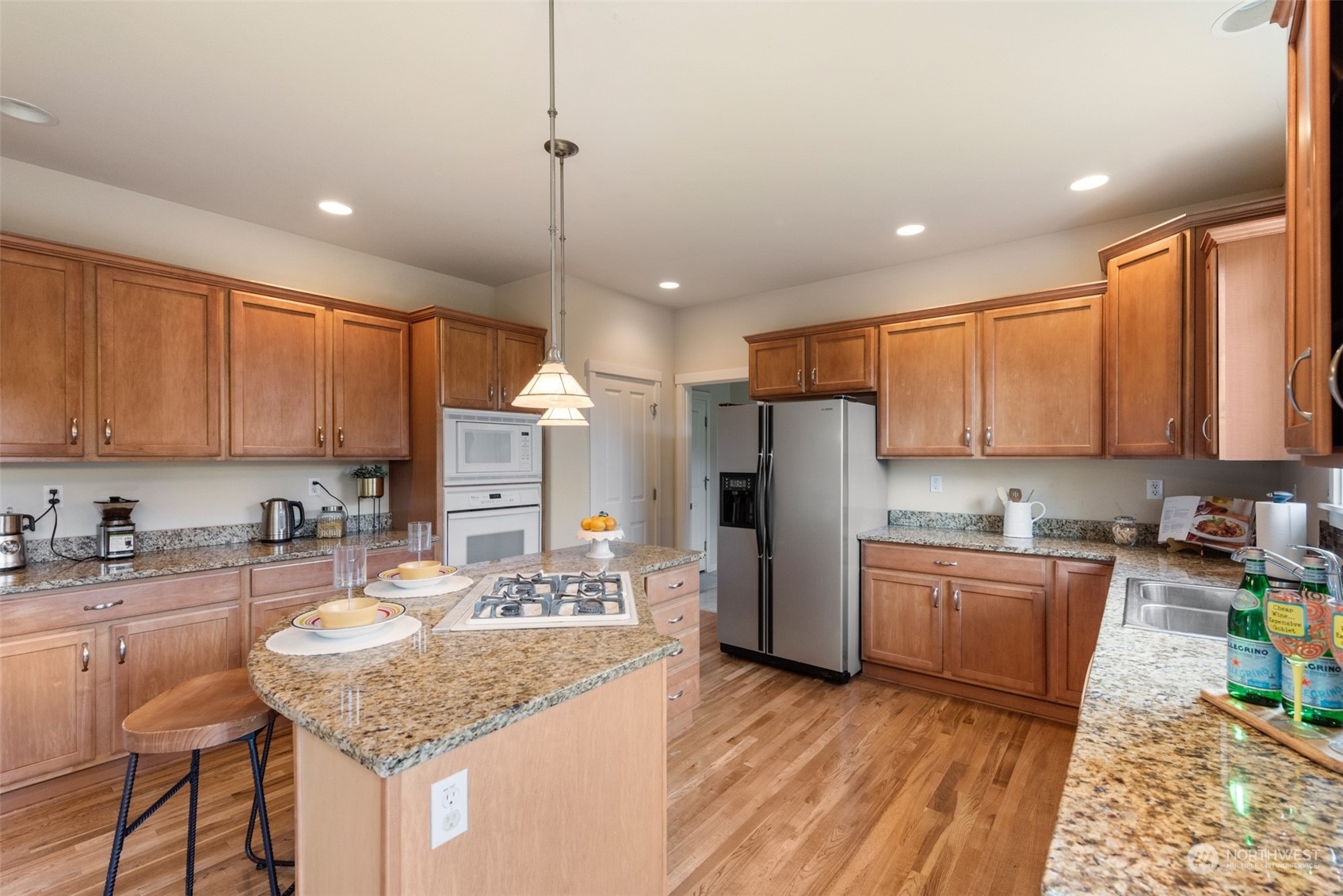 4022 220th Street Southeast Bothell, WA 98021 - Photo 9 of 24 a kitchen with stainless steel appliances granite countertop a sink refrigerator and cabinets