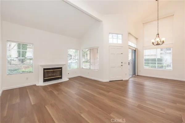 wooden floor fireplace and windows in an empty room