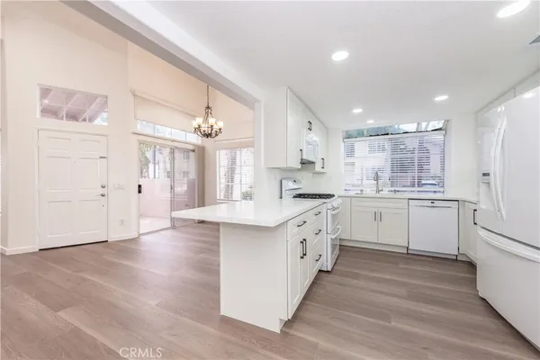 a kitchen with white cabinets stainless steel appliances and window