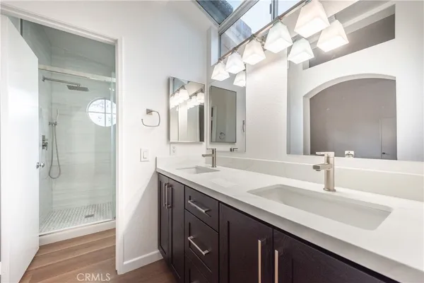 a bathroom with a double vanity sink mirror and shower