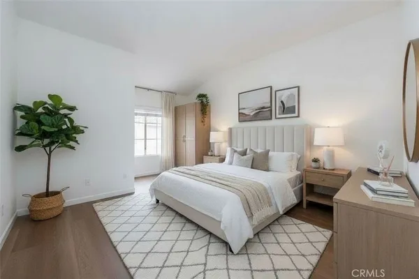 a bedroom with a bed and a potted plant