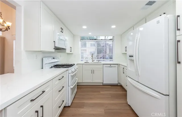 a kitchen with white cabinets and appliances