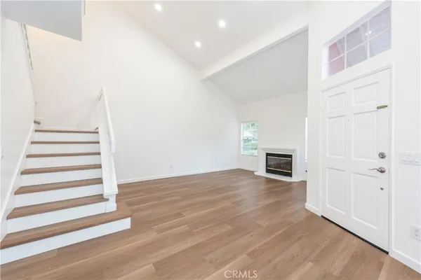 a view of a livingroom with wooden floor and staircase