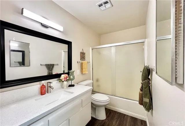 a bathroom with a sink mirror vanity and toilet