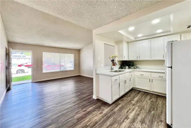 a kitchen with stainless steel appliances white cabinets and wooden floors