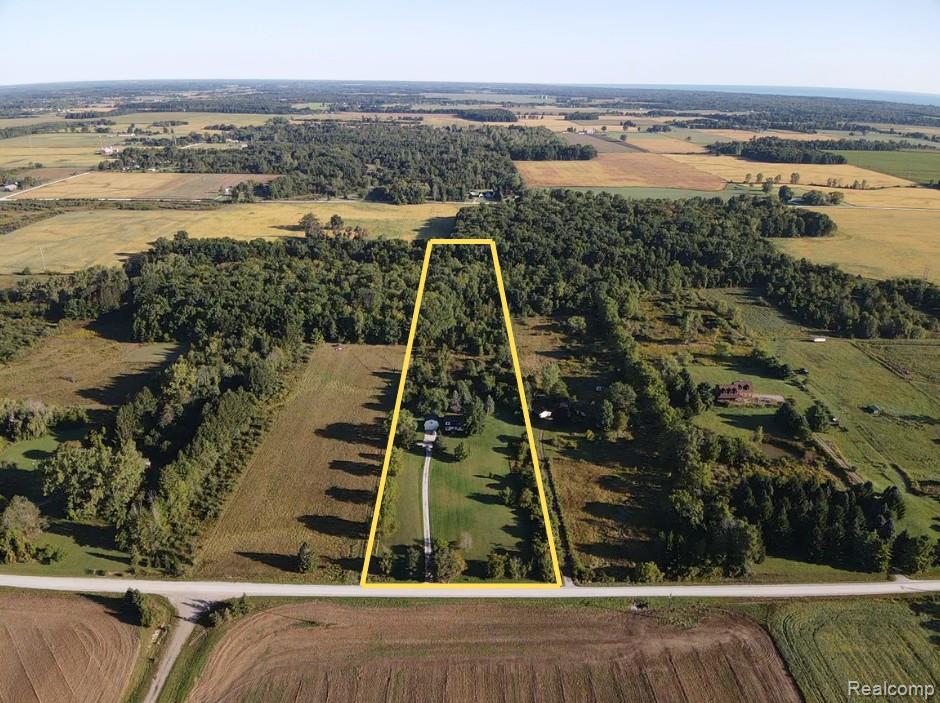 5282 McIntyre Road North Street, MI 48049 - Photo 2 of 53 Expansive property featuring a paved road frontage, mature tree lines, and a residential structure with a long driveway