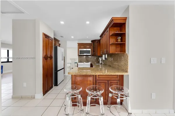 a kitchen with stainless steel appliances granite countertop a refrigerator and a sink