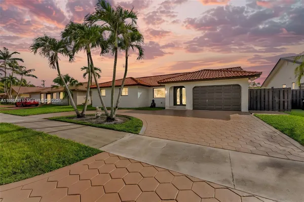 front view of a house with a yard and an trees