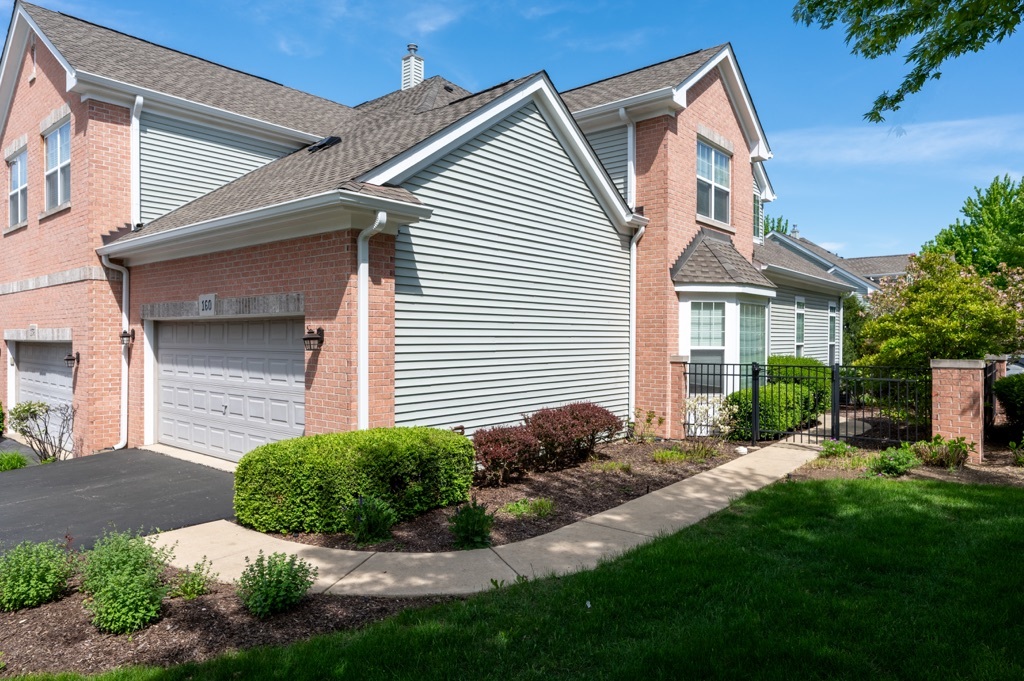 a front view of a house with a yard and potted plants