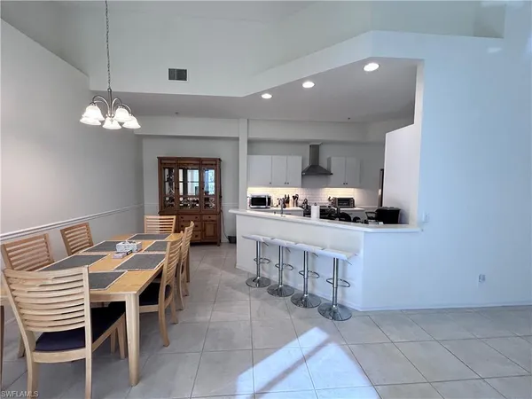 a kitchen with a dining table chairs and refrigerator
