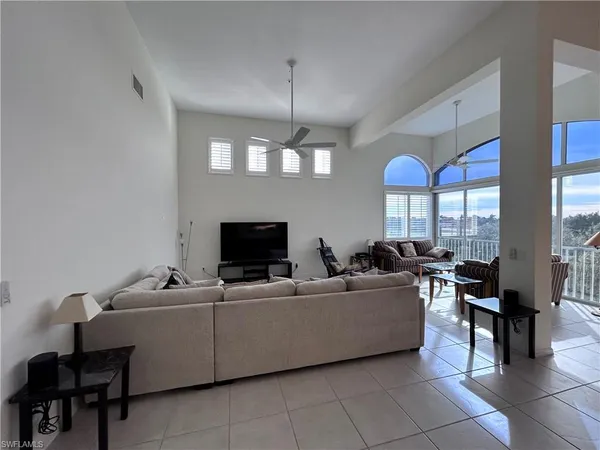 a living room with furniture a chandelier a fireplace and a flat screen tv