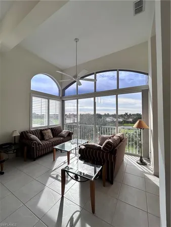 a living room with furniture and floor to ceiling windows