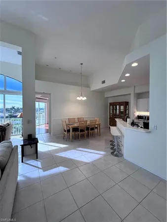 a living room with furniture a dining table and kitchen view