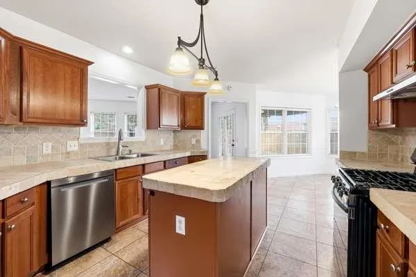 a kitchen that has a sink and a stove in it