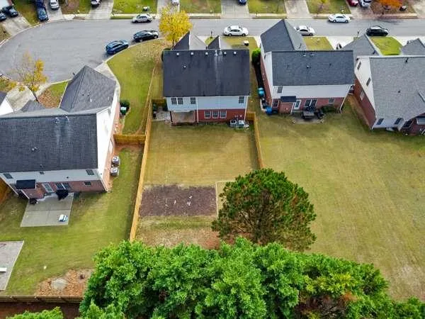 an aerial view of a house with swimming pool and large trees