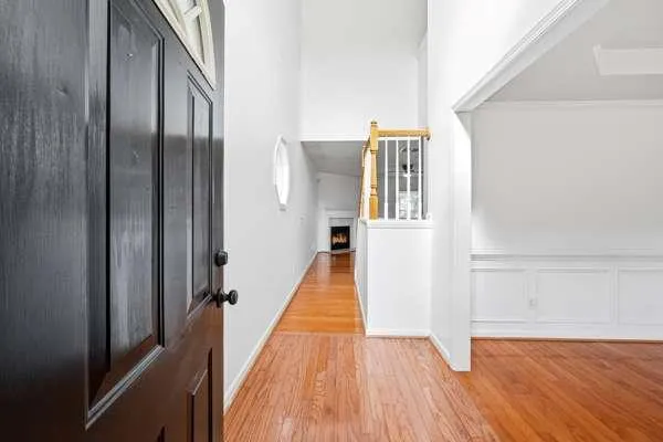 a view of a hallway with wooden floor and staircase