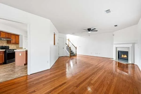 a view of empty room with wooden floor and fireplace