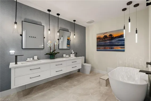 a spacious bathroom with a double vanity sink a large mirror a bathtub and a shower