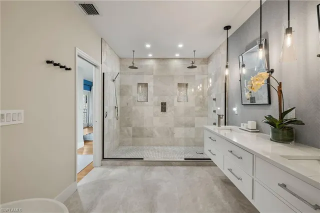 a bathroom with a double vanity sink toilet and shower