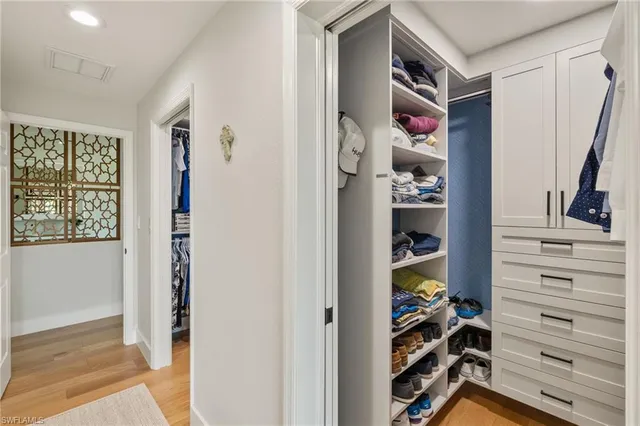 a view of walk in closet with clothes and shoes