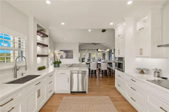 a large open kitchen with stainless steel appliances kitchen island granite countertop a large counter top and sink