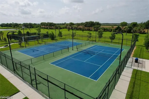 a view of a tennis ground with large trees