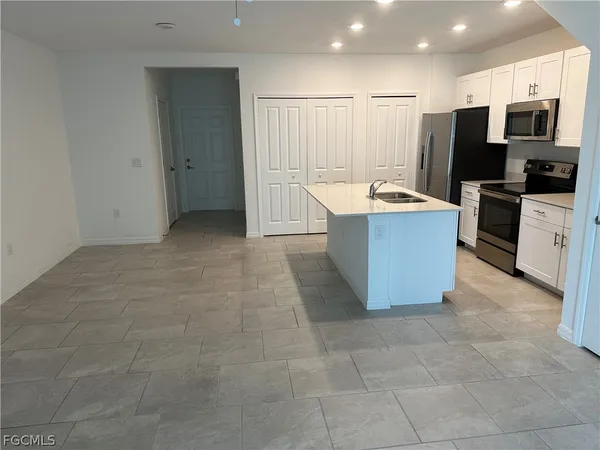 a large kitchen with cabinets and stainless steel appliances