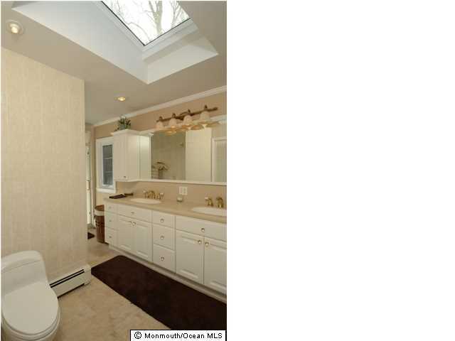 14 Highpoint Road Holmdel, NJ 07733 - Photo 13 of 17 a bathroom with a sink a toilet a mirror and vanity