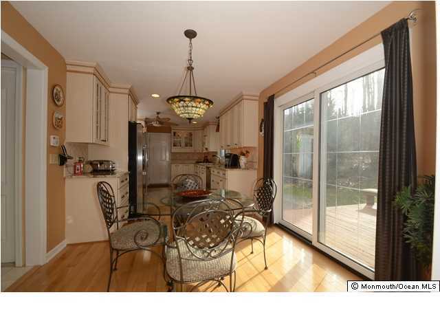 14 Highpoint Road Holmdel, NJ 07733 - Photo 6 of 17 a living room with furniture a flat screen tv and a floor to ceiling window