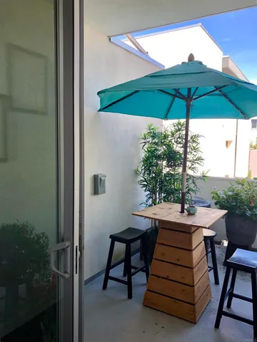 a view of patio with a table and chairs under an umbrella