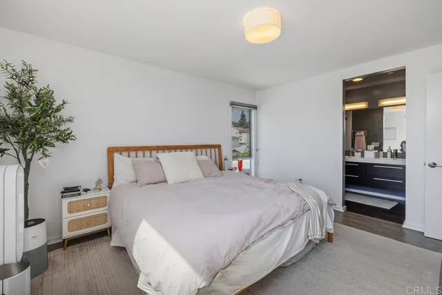 a bedroom with a bed and a potted plant