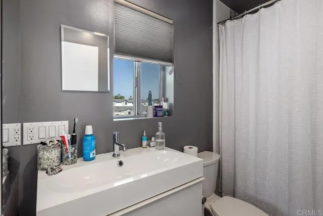 a bathroom with a sink a toilet and mirror