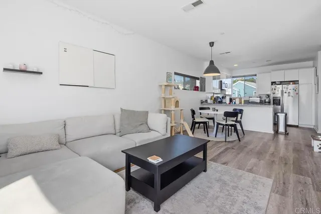 a living room with furniture a rug and white walls