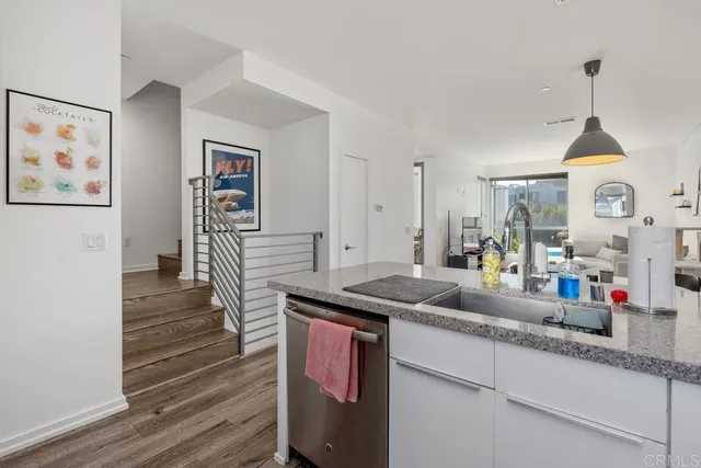 a kitchen with granite countertop a sink cabinets and wooden floor
