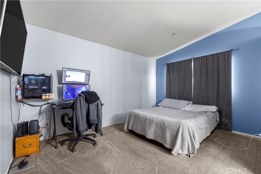 15417 Tobarra Road Fontana, CA 92337 - Photo 22 of 29 a bedroom with bed table and a flat screen tv