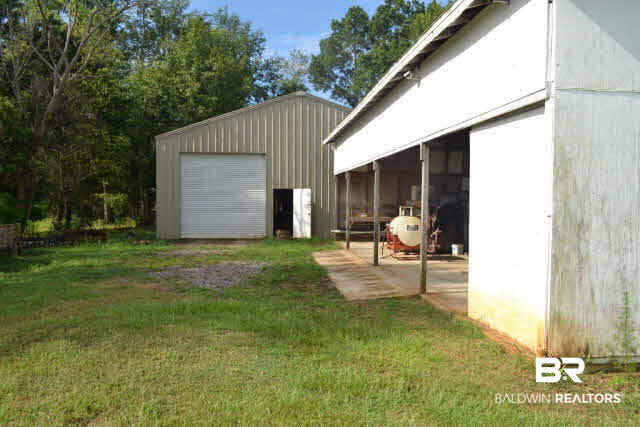 27608 County Road 65 Loxley, AL 36551 - Photo 5 of 32 The 28x48 covered shed has a concrete slab.The 40x50 metal building has overhead doors on both sides and houses all equipment.