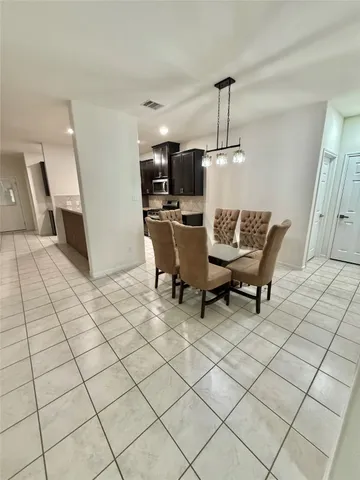 a living room with couches chairs and kitchen view