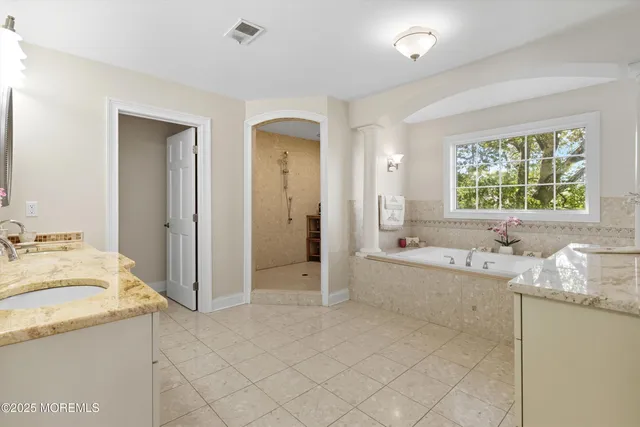 a spacious bathroom with a granite countertop tub sink and mirror