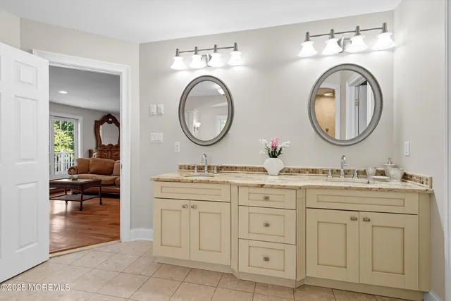 a bathroom with a granite countertop double vanity sink and a mirror