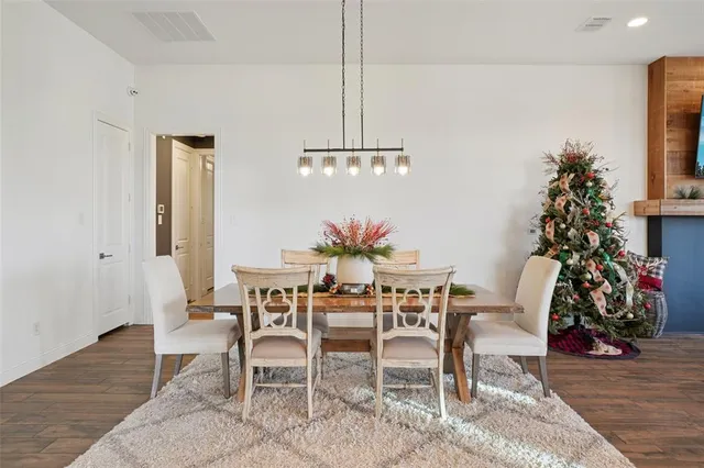 a dining room with furniture a chandelier and wooden floor