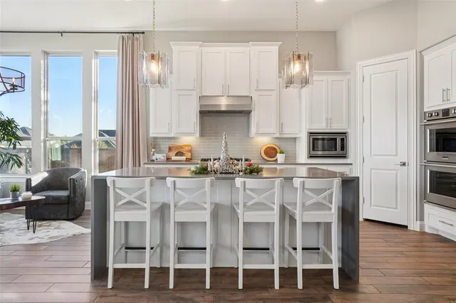 a kitchen with stainless steel appliances granite countertop a table and chairs