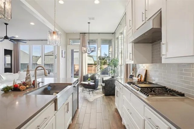 a kitchen with stainless steel appliances a sink a stove and a wooden floors