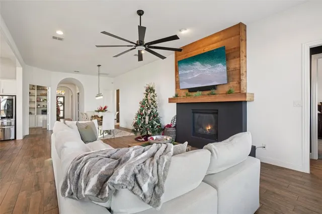 a bedroom with a bed a mirror on dresser and a flat screen tv