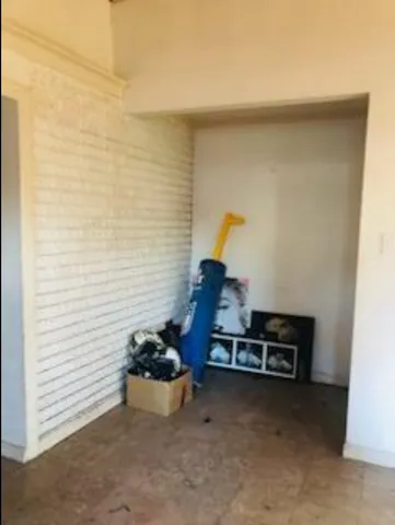a view of an empty room with a fireplace and a window