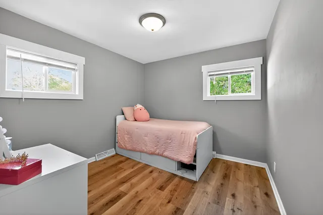 a bedroom with a bed and wooden floor