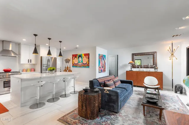 a living room with furniture a rug and a wall painting