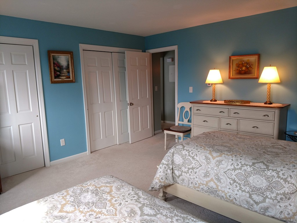 683 Old Post Road, Unit 18 Dennis, MA 02638 - Photo 11 of 25 a bedroom with a bed and a lamp on dresser